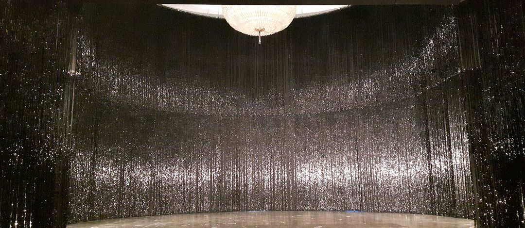 Theaterbühne, die im Halbrund mit einem silbernen Glitzervorhang ausgehängt ist